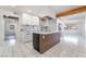 Modern kitchen with island, white cabinetry, and marble-style tile flooring at 116 W Victory Rd, Henderson, NV 89015