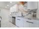 Modern kitchen with white cabinetry, stainless appliances, and marble-style tile flooring at 116 W Victory Rd, Henderson, NV 89015