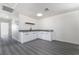 Bright room with gray wood-look flooring and a kitchenette with white cabinets and black fixtures at 116 W Victory Rd, Henderson, NV 89015