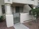 Close-up of a stucco condominium building's gated front patio featuring a secure wrought iron gate at 1341 Cinder Rock Dr # 101, Las Vegas, NV 89128