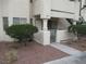 Exterior shot of a stucco condominium building with landscaped front yard and gated patio at 1341 Cinder Rock Dr # 101, Las Vegas, NV 89128