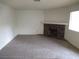 Carpeted living room with a stone fireplace and mantle provides a cozy and inviting space at 1341 Cinder Rock Dr # 101, Las Vegas, NV 89128