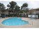 Community pool and spa surrounded by landscaping and lounge chairs at 1341 Cinder Rock Dr # 101, Las Vegas, NV 89128