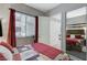 Well-lit bedroom with mirrored closet doors, a colorful quilt, and a bright window view at 15 Via Mantova # 308, Henderson, NV 89011