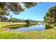 Lakeside view of community park featuring a serene lake with a fountain, green grass, and trees at 15 Via Mantova # 308, Henderson, NV 89011
