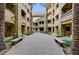 Expansive courtyard with tall palm trees, decorative benches, paver stones, and multi-story buildings at 15 Via Mantova # 308, Henderson, NV 89011