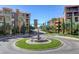 Front entrance to community with fountain, roundabout, mature trees, and beautiful landscaping at 15 Via Mantova # 308, Henderson, NV 89011