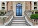 Grand entryway featuring ornate iron doors, stone steps, and manicured landscaping at 15 Via Mantova # 308, Henderson, NV 89011