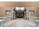 Grand hallway featuring textured walls, stone benches, decorative ironwork, and glass entry doors at 15 Via Mantova # 308, Henderson, NV 89011