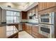 Modern kitchen showcasing sleek granite countertops, stainless steel appliances, and ample natural light through a large window at 15 Via Mantova # 308, Henderson, NV 89011
