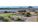 Picturesque park with bench seating, beautiful flowerbeds, gravel paths, and a serene lake view at 15 Via Mantova # 308, Henderson, NV 89011