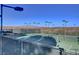 Outdoor tennis courts surrounded by fencing featuring mountain views in the background at 15 Via Mantova # 308, Henderson, NV 89011