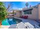 Inviting backyard pool with lounge chairs and red chairs, perfect for relaxing and entertaining guests on a sunny day at 1601 Becke Cir, Las Vegas, NV 89104