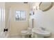 Bathroom featuring a white shower with curtain, toilet, pedestal sink, and decorative mirror at 1601 Becke Cir, Las Vegas, NV 89104