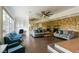 Bright living room with a stone fireplace, ceiling fan, built-in shelving, and comfortable seating arrangement at 1601 Becke Cir, Las Vegas, NV 89104