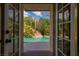 Stunning view of the lush backyard pool area, seen through elegant glass doors, offering a private tropical retreat at 1601 Becke Cir, Las Vegas, NV 89104
