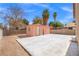 Spacious backyard with a concrete patio, two storage sheds, and desert landscaping at 1892 Falcon Ridge St, Las Vegas, NV 89142