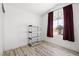Bright bedroom with wood-look flooring, arched window with backyard views, and a closet at 1892 Falcon Ridge St, Las Vegas, NV 89142