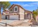 Inviting front exterior showcases a two-story design with a two-car garage and a charming, landscaped yard at 1892 Falcon Ridge St, Las Vegas, NV 89142