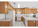 Well-lit kitchen boasts ample wood cabinetry, white appliances, and sleek countertops for a clean, modern feel at 1892 Falcon Ridge St, Las Vegas, NV 89142