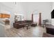 Spacious living room with wood-look flooring, a sectional sofa, and an open layout to the dining area at 1892 Falcon Ridge St, Las Vegas, NV 89142