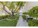 Lush backyard featuring manicured lawn, mature trees, and shaded stone pathway at 2339 Prometheus Ct, Henderson, NV 89074