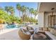 Lush outdoor living space with comfortable seating near the pool, surrounded by tropical plants and serene landscaping at 2339 Prometheus Ct, Henderson, NV 89074