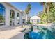 Backyard view highlighting a pool and guesthouse against the backdrop of a two-story home with large windows at 2339 Prometheus Ct, Henderson, NV 89074