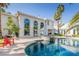 Backyard features a pool, jacuzzi, and comfortable chairs, framed by an elegant two-story home and tropical landscaping at 2339 Prometheus Ct, Henderson, NV 89074