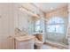 Neutral-toned bathroom with glass enclosed shower, large mirror, and ample lighting at 2339 Prometheus Ct, Henderson, NV 89074