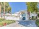 Elegant two-story home featuring a blue double-door entry, white exterior, and a three-car garage at 2339 Prometheus Ct, Henderson, NV 89074