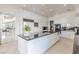 Bright kitchen with modern white cabinets, black countertops, and an island; open to a breakfast bar area at 2339 Prometheus Ct, Henderson, NV 89074