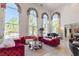 Bright living room features high ceilings, unique windows, and plush seating with views of the outdoor pool and landscaping at 2339 Prometheus Ct, Henderson, NV 89074