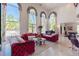 Bright and open living room featuring stylish red sofas, tall windows, and bright decor at 2339 Prometheus Ct, Henderson, NV 89074