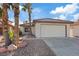 Charming single-story home with a two-car garage, desert landscaping, and mature palm trees at 2547 Wolverton Ave, Henderson, NV 89074