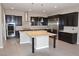 Gourmet kitchen features dark cabinetry, granite countertops, stainless steel appliances, and island with seating at 2822 Poseidon Shore Ave, Henderson, NV 89052