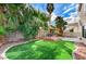 Lush backyard with an open air gazebo on a wood deck, landscaped garden and palm trees at 293 Winter Creek Ct, Henderson, NV 89074