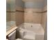 Bathroom featuring a bathtub with tile surround and a shower, with updated fixtures and a tiled accent stripe at 2967 Juniper Hills Blvd # 104, Las Vegas, NV 89142