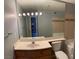 Bright bathroom featuring a wide mirror, single sink vanity, and a toilet next to a tile-surround tub at 2967 Juniper Hills Blvd # 104, Las Vegas, NV 89142