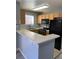 Kitchen featuring wood cabinets, laminate counters, black appliances and bar seating at 2967 Juniper Hills Blvd # 104, Las Vegas, NV 89142