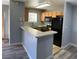 Kitchen featuring wood cabinets, laminate counters, black appliances and bar seating at 2967 Juniper Hills Blvd # 104, Las Vegas, NV 89142