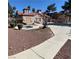 Outdoor community pool area with a spa, pool house and a paved walkway with red rock ground covering at 2967 Juniper Hills Blvd # 104, Las Vegas, NV 89142