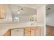 Kitchen featuring white tile countertops, wood cabinets, and an open view to the spacious living area at 3673 Ian Thomas St # 201, Las Vegas, NV 89129