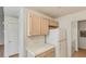 Efficient kitchen with light wood cabinets, white appliances, and adjacent laundry area at 3673 Ian Thomas St # 201, Las Vegas, NV 89129