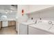 Bright laundry area with appliances, overhead shelving, and adjacent kitchen access at 3673 Ian Thomas St # 201, Las Vegas, NV 89129