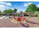 Backyard seating area with red Adirondack chairs around a fire pit with pool in the background at 3681 S Rosecrest Cir, Las Vegas, NV 89121