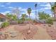Desert-landscaped backyard with palm trees, fire pit, and desert landscaping at 3681 S Rosecrest Cir, Las Vegas, NV 89121