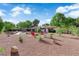 Expansive backyard featuring a pool, fire pit with chairs, mature trees, and desert landscaping at 3681 S Rosecrest Cir, Las Vegas, NV 89121