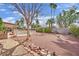 Backyard with mature palms, desert landscaping, fenced pool, and covered patio at 3681 S Rosecrest Cir, Las Vegas, NV 89121