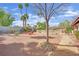 Wide backyard featuring desert landscaping, a fire pit, seating area, and various palms at 3681 S Rosecrest Cir, Las Vegas, NV 89121